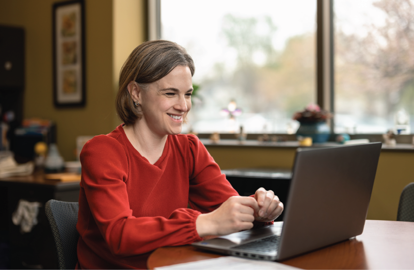 Professional smiling at computer during learning session.