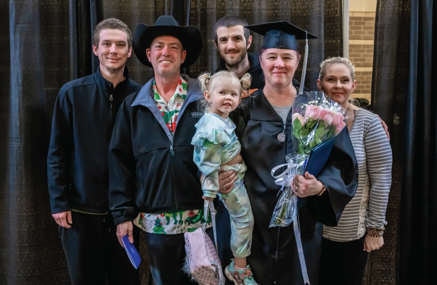 A graduating woman surrounded by her family.