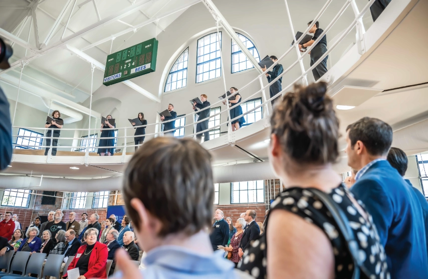 Students singing in the balcony of the new Higgins Hall.