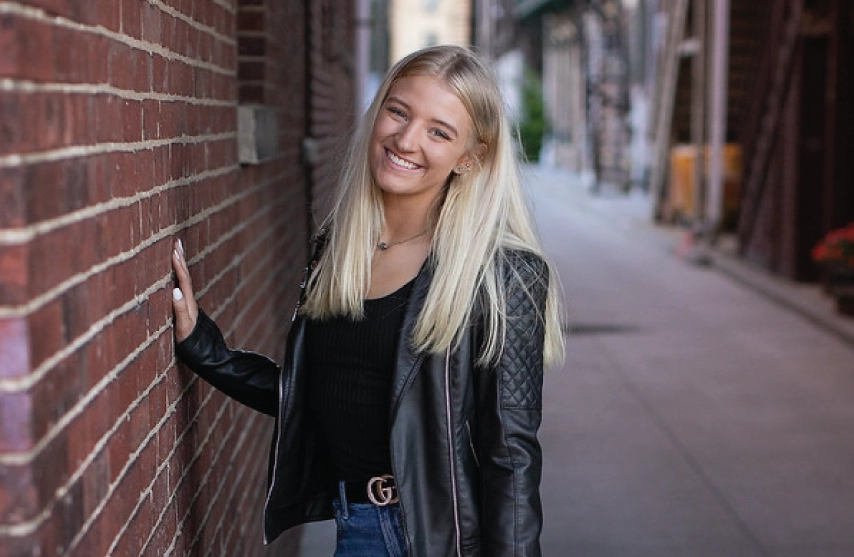 A student posing for a picture outside.