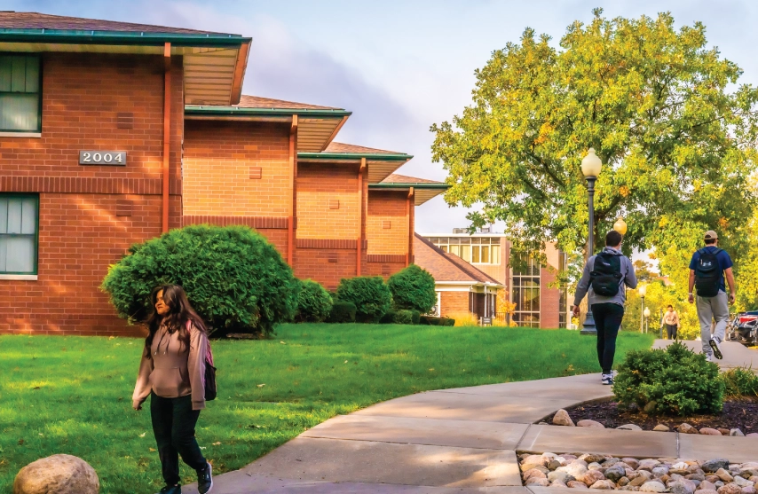 Students walking outside near campus houses.