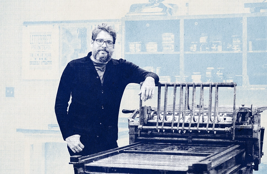 Associate professor and chair Joseph Lappie, MFA, poses next to printing equipment in his classroom.
