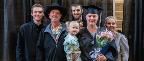 A graduating woman surrounded by her family.