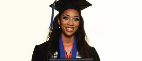 A smiling women holding a diploma from Mount Mercy University.