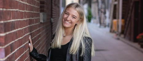 A student posing for a picture outside.