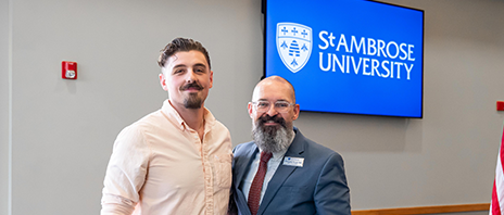 Mike Thorson stands next to the Dean of Students during the Veteran's ceremony.