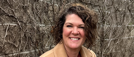 Nicole Sakraida, M.Ed, smiles into the camera against a brick background.