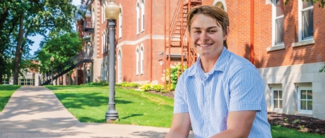 Ryan Russo sits outdoors on a sunny day.
