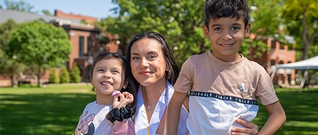 Nursing student Sydnee Cosner '26 poses on the SAU lawn with two of her children.