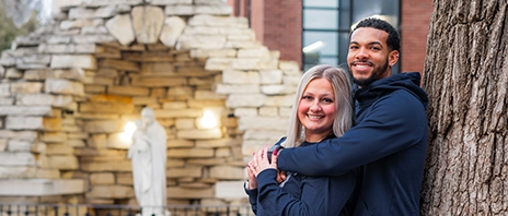 Paige (Fiscella) ‘23 and Yemi Ward ‘23, ‘26 MOL pose for a photo at The Grotto at St. Ambrose University.