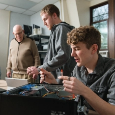 A group of people working on the parts of a computer.