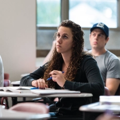 A group of students taking notes in a psychology class.