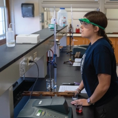 Two women in a chemistry lab conducting experiments and analyzing data.