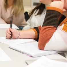 A group of students writing at a table.