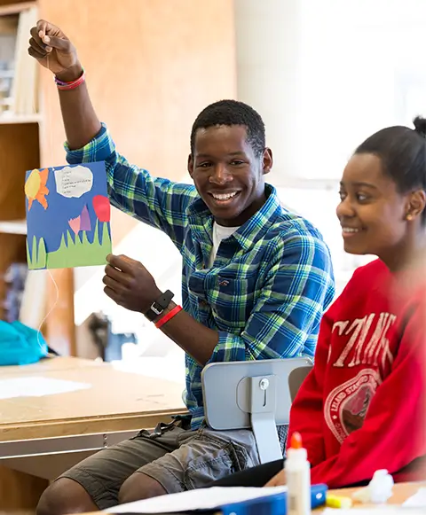 Student holding up an art project.