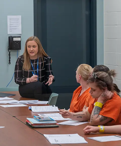 A woman instructs a group of female inmates at the local jail.