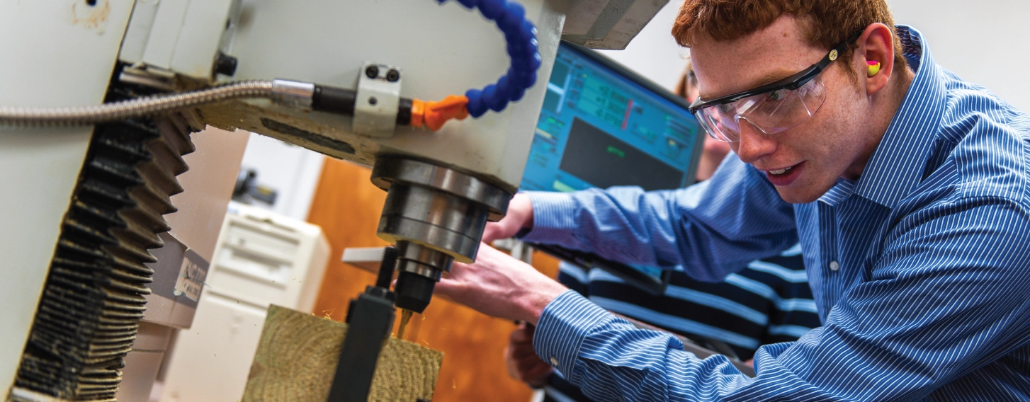 Student focused on engineering project in classroom.