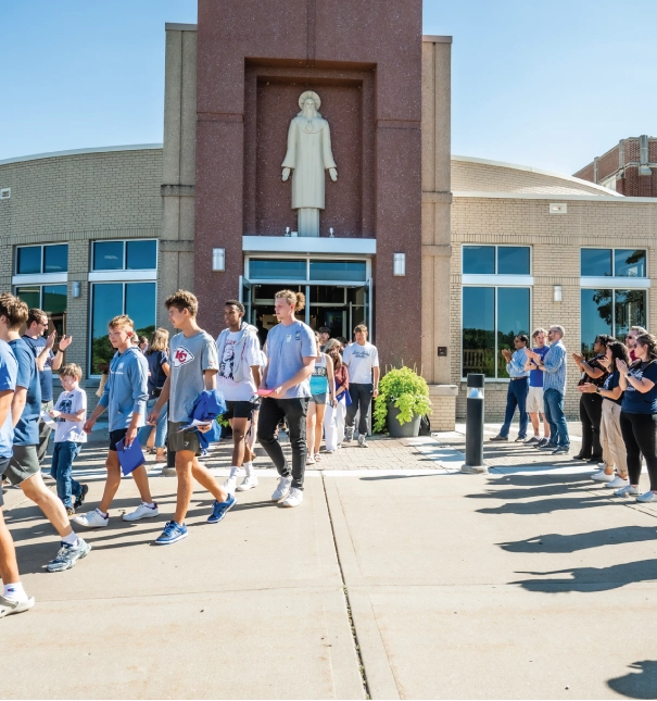 Students exiting chapel on a sunny day.