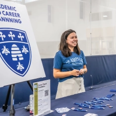 A student standing at a table with a woman at the Career Center.