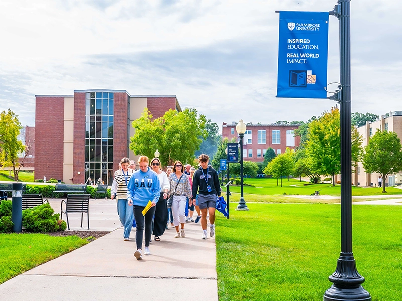 A group of potential students walk around St. Ambrose University's campus.