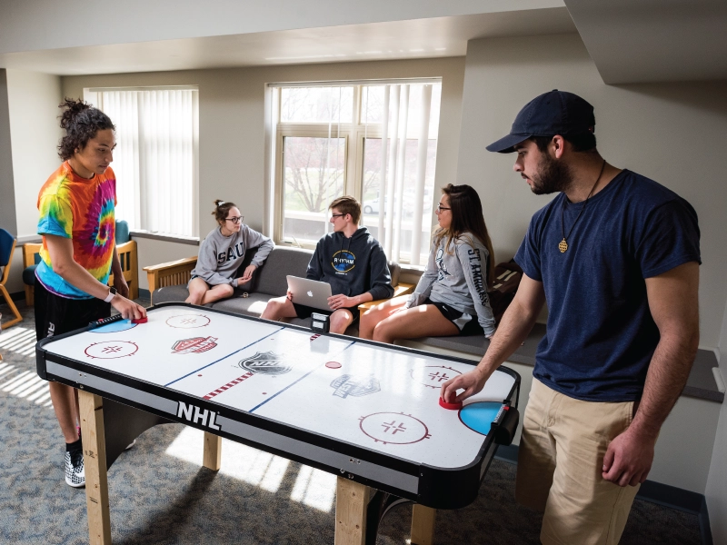 students talking with each other in a common space and playing a game.