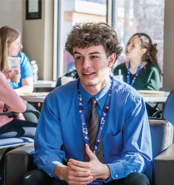 One male student sitting in an admissions event.