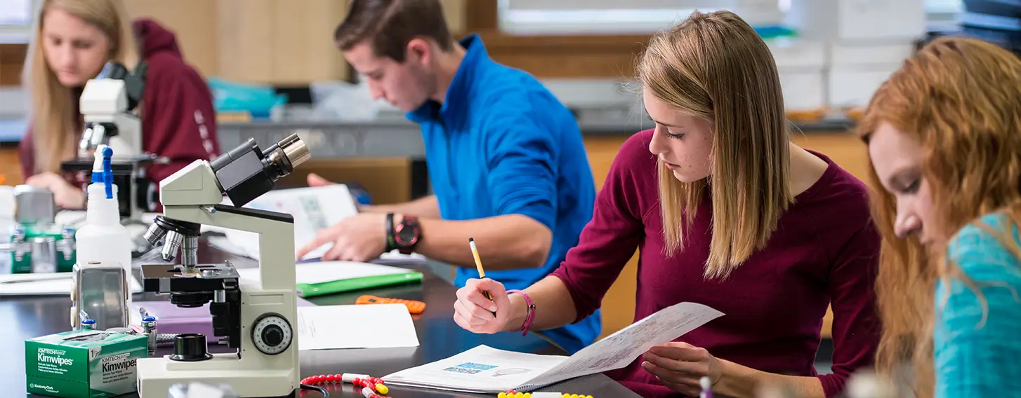 A group of students doing labwork in a biology lab.