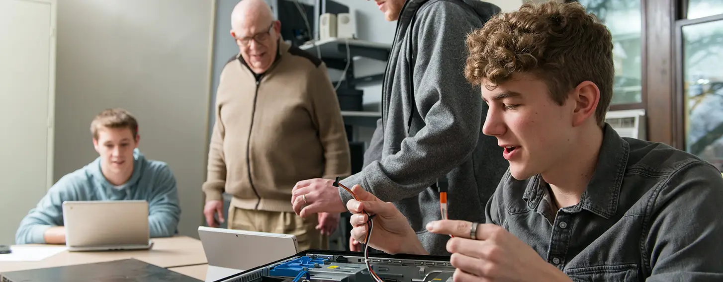 A group of people working on the parts of a computer.