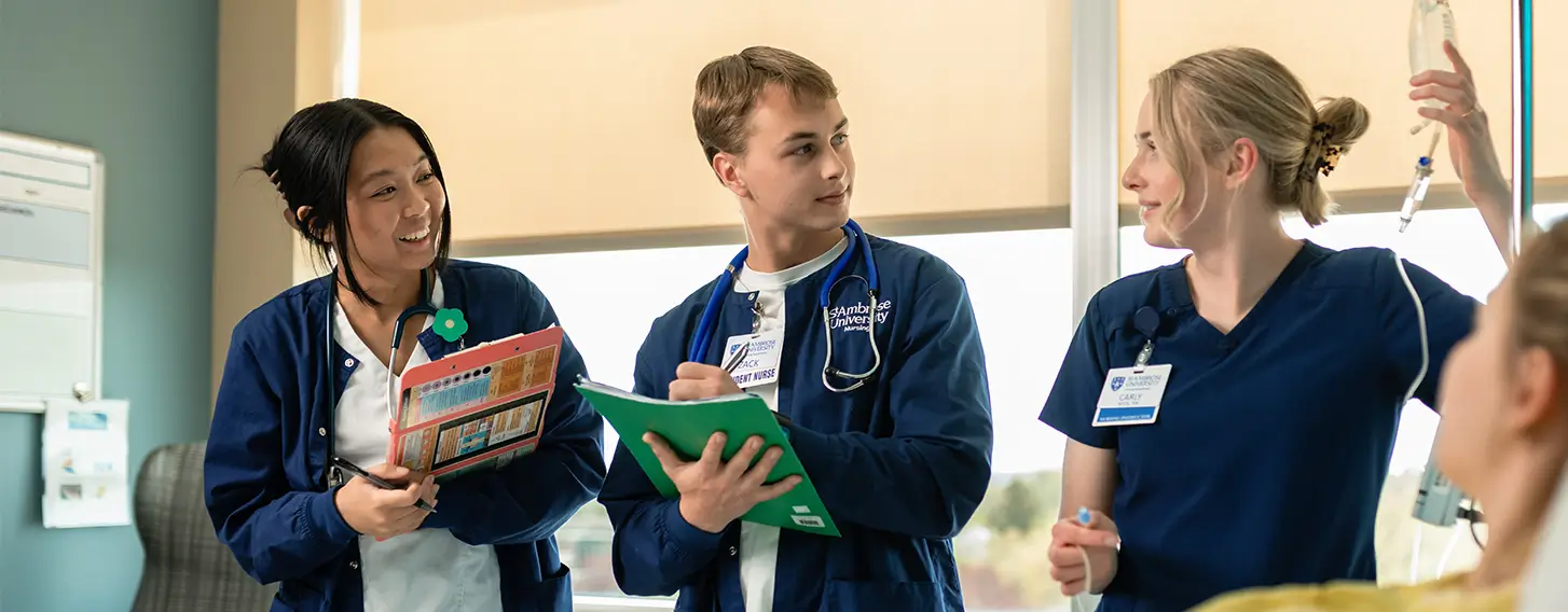 A group of nursing students providing care to a patient in a hospital room.