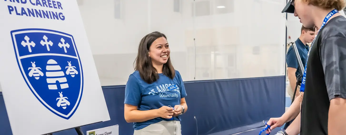 A student standing at a table with a woman at the Career Center.