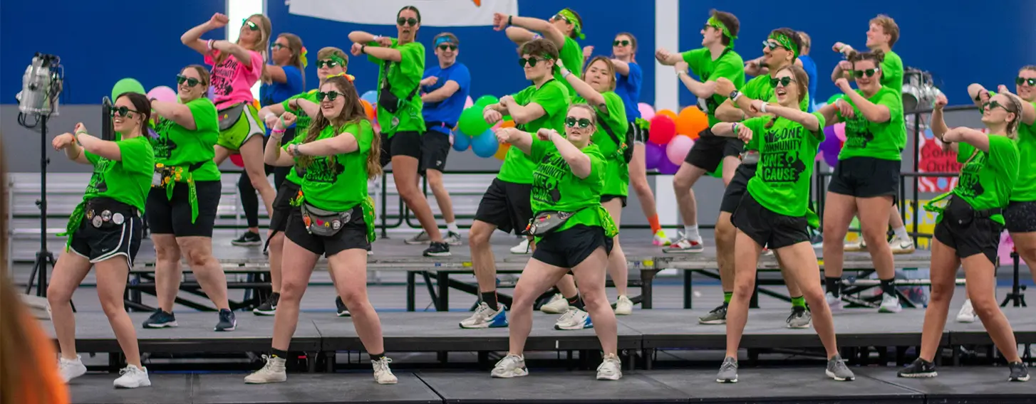 A group of students dancing on a stage for the big Dance Marathon event