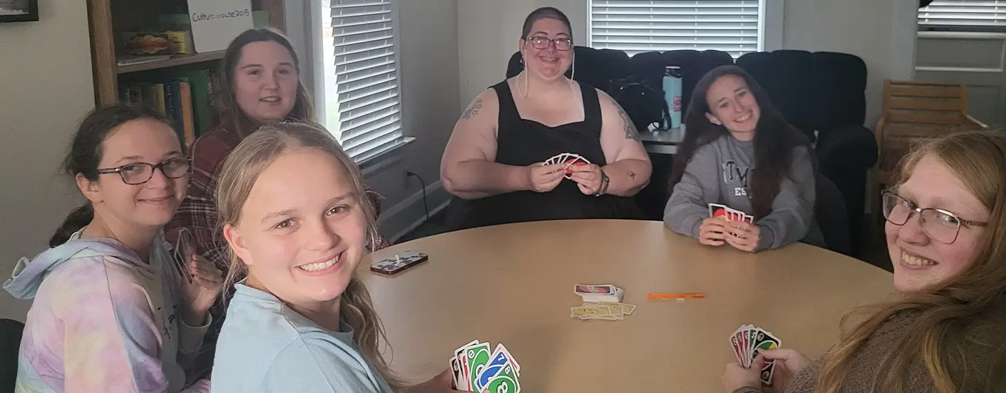 A group of students playing a card came at a table together