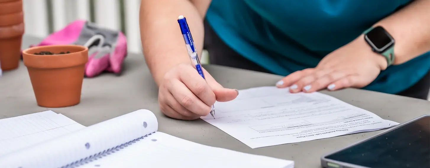 A student filling out paperwork on a desk