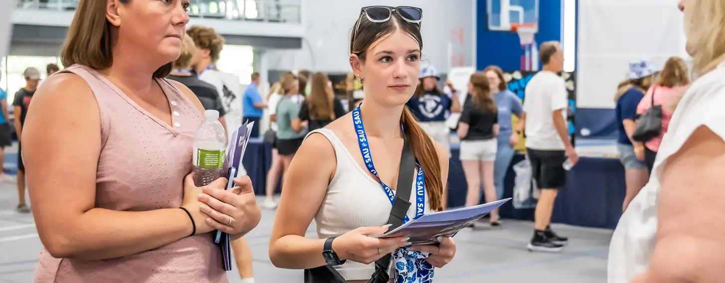 A student and a parent at a informational fair inside