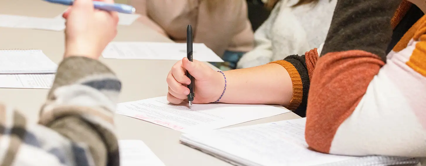 A group of students writing at a table