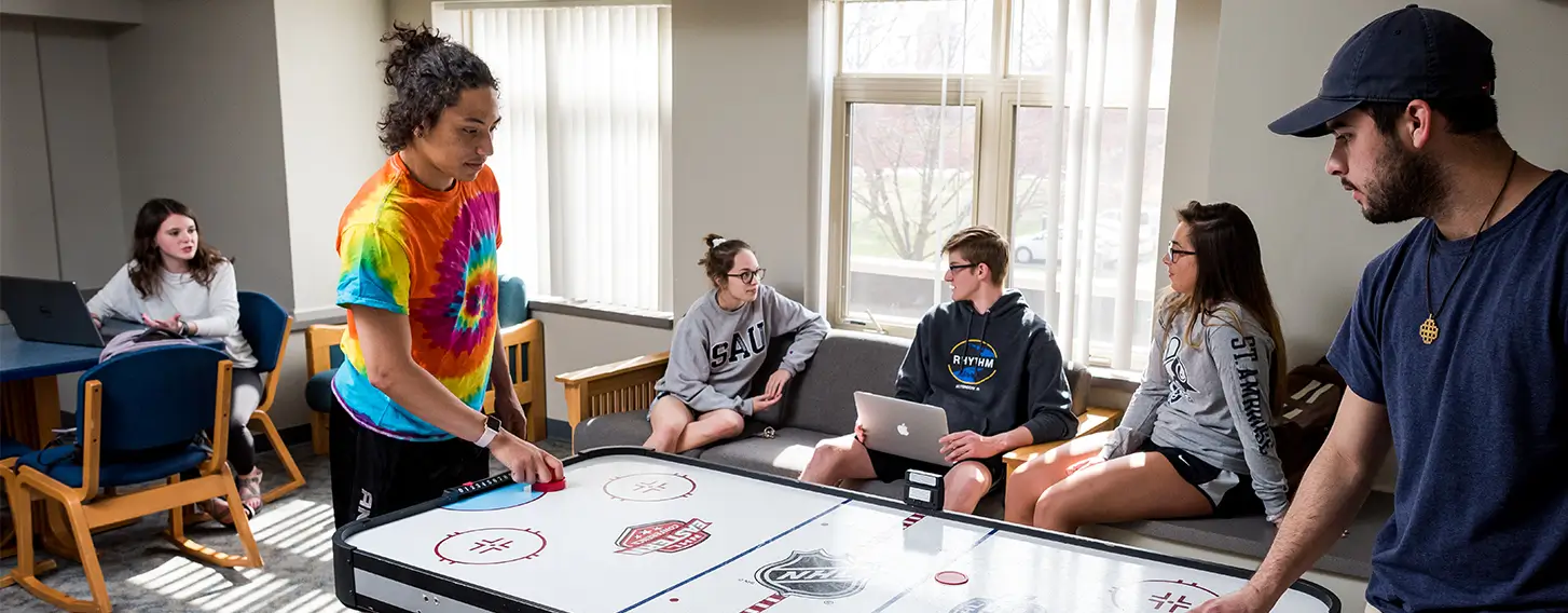 students talking with each other in a common space and playing a game