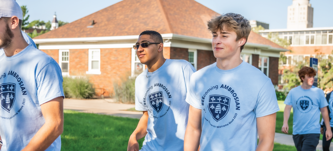 Two students walking outdoors wearing shirts reading 