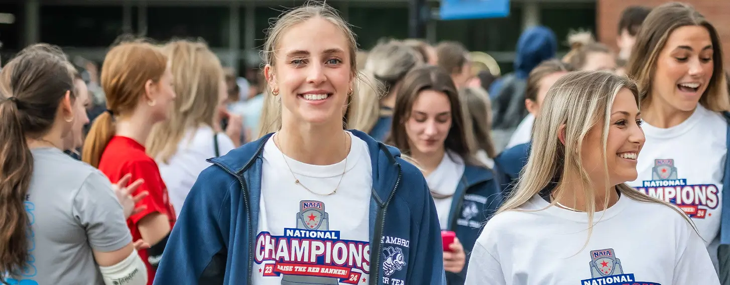 A group of female cheerleaders wearing their white Champions t-shirts.