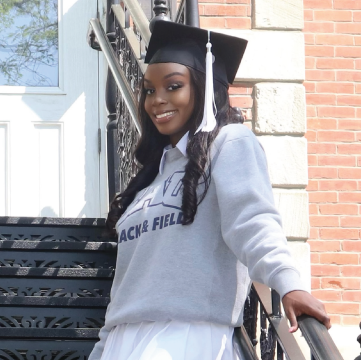 Photo of Leah Rose outdoors wearing a graduation cap.