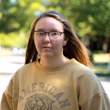 Student standing outdoors looking at camera.