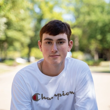 Student outdoors looking directly at camera.