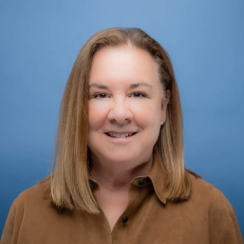 Patricia Snyder smiles into the camera against a blue background.