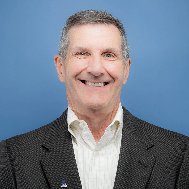 Phil Doherty smiles into the camera against a blue background.