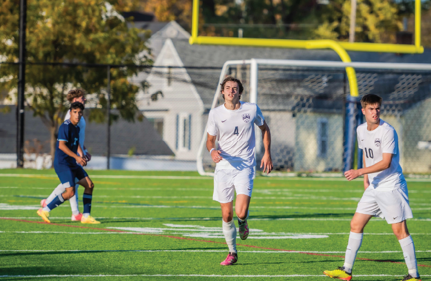 Two men's soccer players running in a soccer game