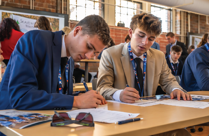 Two students working together while writing notes