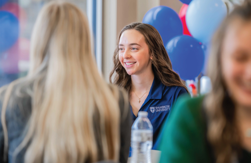 A student smiling while talking to someone