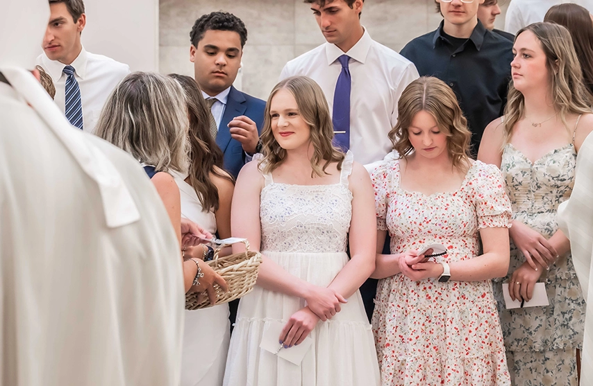 Students stand together during the St. Ambrose University Commencement Mass