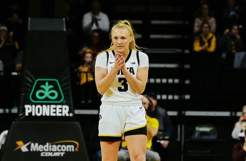 An image of Sydney Affolter at the University of Iowa walking across a basketball court.