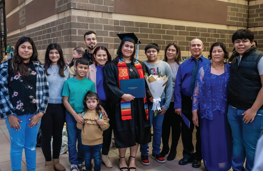 A large family standing next to a graduating member of the family.