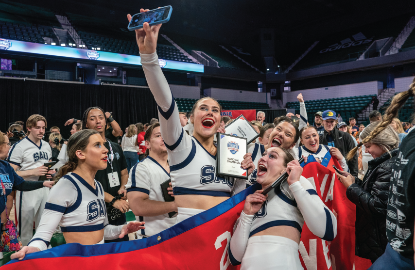 Cheerleaders celebrate with national championship trophy.